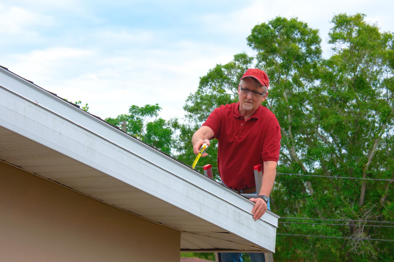 Inspector measuring a roof edge for wind mitigation documentation